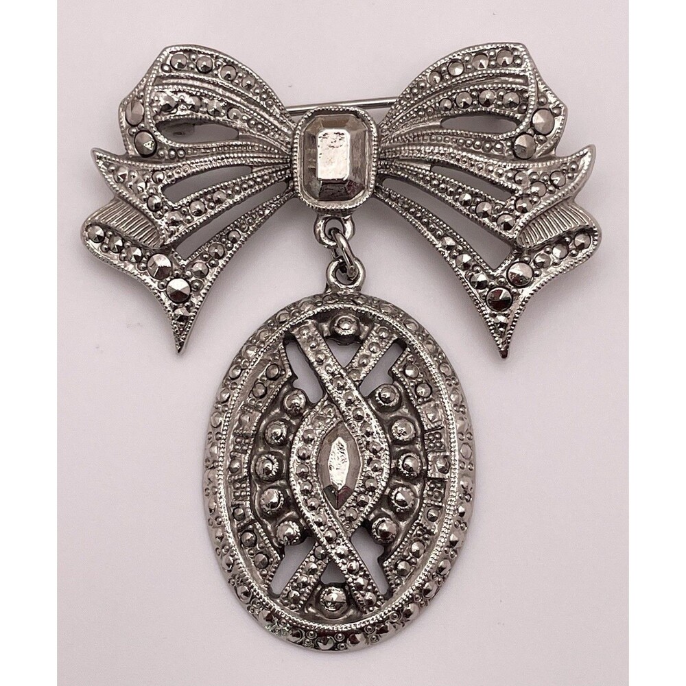 Silver Tone Marcasite Style Ribbon with Dangling Open Work Medallion Brooch Pin